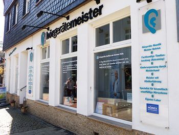 Fassade eines Hörgeräteakustikers mit Schaufenstern und Infos rund um Hörgeräteberatung.